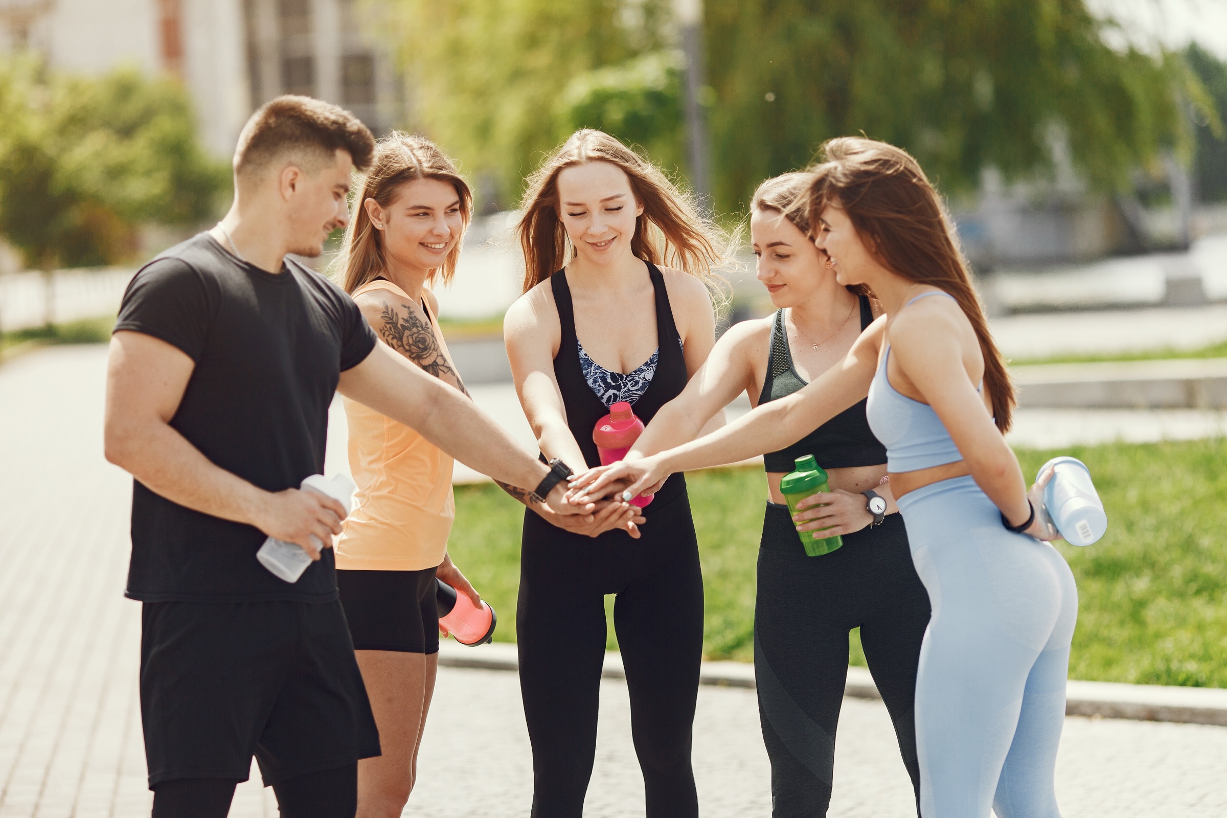 group of one boy and four girls standing in the park
